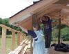 Christina primering the overhang and David putting blocks between the rafters. 