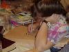 Christina coloring in engraved words with a brown marker. 